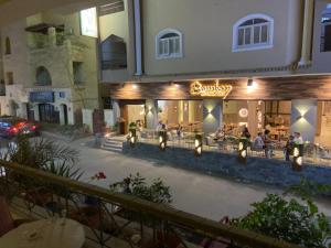 a restaurant with people sitting outside of it at night at Bahga Palace 1 Residential Apartments in Hurghada