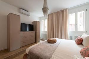 um quarto com uma cama e uma televisão numa cómoda em MURANO Place - MISTRO House em Murano