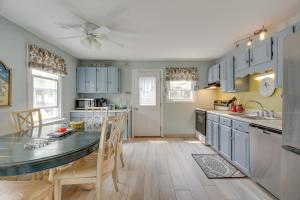 a kitchen with blue cabinets and a table with chairs at Ideal Narragansett Location with Furnished Deck! in Narragansett