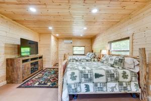 a log cabin bedroom with two beds and a flat screen tv at Charming Cabin Near Roaring River State Park! in Cassville