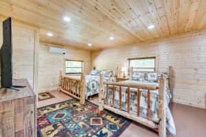 una baita di tronchi con 2 letti in una camera di Charming Cabin Near Roaring River State Park! a Cassville