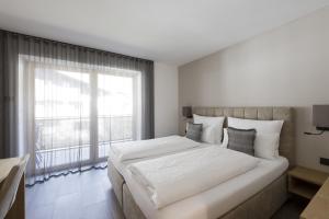 um quarto branco com uma cama grande e uma janela em Residence Sonja - Apartment Betula em Rabla