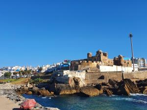 a view of a beach with a castle and the ocean at Maison Familiale, vue sur mer à 5 minutes in Larache