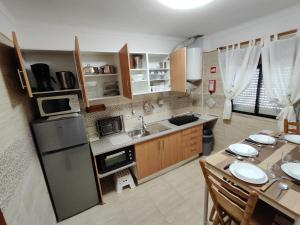 a small kitchen with a table and a refrigerator at Sol Nascente Apartment in Albufeira
