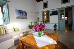 ein Wohnzimmer mit einer Blumenvase auf dem Tisch in der Unterkunft Chrissa's loft in Patmos