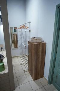 a bathroom with a wooden cabinet and a mirror at Chrissa's loft in Patmos