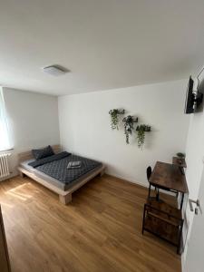 een slaapkamer met een bed en een houten vloer bij Aspava Apartments in Günzburg
