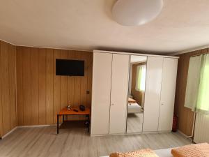 um quarto com armários brancos e uma televisão na parede em Ferienwohnung Jürgen horn em Hohentauern