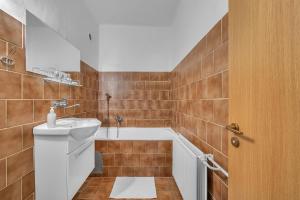 a bathroom with a sink and a bath tub at Hotel Podkost in Libošovice