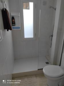 y baño blanco con ducha y aseo. en Alojamiento Playa Centro Corralejo 16 en Corralejo