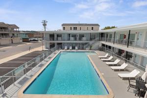 a swimming pool on the roof of a building with chairs at The Beach House in Wildwood