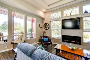 a living room with a couch and a tv at Ocean Shores Retreat with Porch and Canal Views! in Ocean Shores