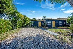 une maison bleue et jaune avec une allée en gravier dans l'établissement New stylish open space: fast Wii-fi and parking, à Fort Lauderdale