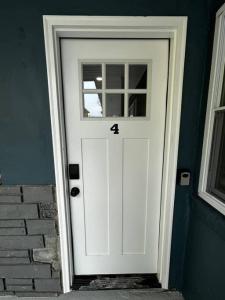 a white door with the number four on it at 318 E Youngs Ave Unit 4 Charming Salty Shore Retreat Your Perfect Getaway in Wildwood