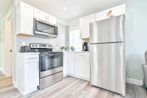 a kitchen with white cabinets and a stainless steel refrigerator at 318 E Youngs Ave Unit 5 Salty Shore Oasis Spectacular Retreat in Wildwood