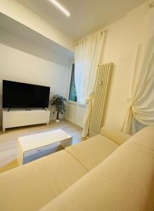 a living room with a couch and a flat screen tv at Apartment Suite - Charlize - in the heart of Milan in Milan