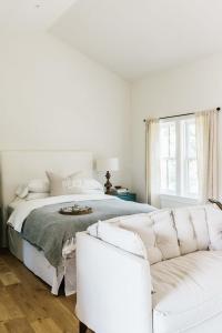 a white bedroom with a bed and a couch at The Wayback Boutique Hotel in Austin