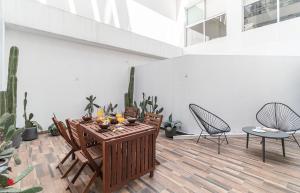 un patio con mesa, sillas y plantas en Casa Alure by Kukun, en Ciudad de México