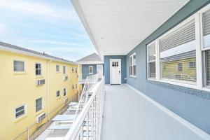 een balkon van een gebouw met geel en blauw bij 318 E Youngs Ave Unit 7 Salty Shore Retreat Coastal Charm Tranquility in Wildwood