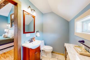 a bathroom with a toilet and a sink and a mirror at The Lodge - Suite #3 in Waterbury