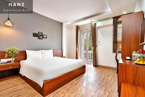 - une chambre avec un lit, un bureau et une fenêtre dans l'établissement HANZ AMI Central Hotel Hanoi, à Hanoï