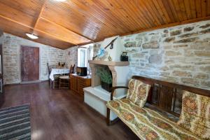 a living room with a stone wall and a couch at Ionian Stone Home with Terrace in Bogdanátika +18 photos