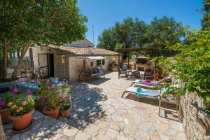 a backyard with a patio with plants and a grill at Ionian Stone Home with Terrace in Bogdanátika