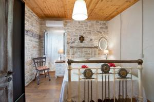 a room with a stone wall and a table with two chairs at Ionian Stone Home with Terrace in Bogdanátika