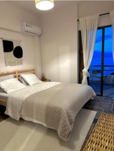 Un dormitorio con una cama grande y una ventana en SeaTerra Boutique suite, en Kalamos