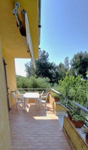 eine Terrasse mit einem Tisch und Stühlen auf dem Balkon in der Unterkunft La Corte sul Conero Casa Vacanze in Camerano