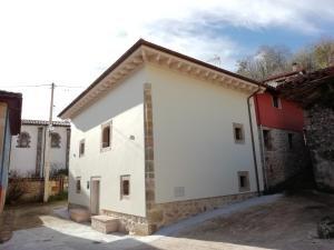 ein weißes Haus mit einem roten Gebäude in der Unterkunft Picos de Europa Chic & Cool Apartments in Puertas