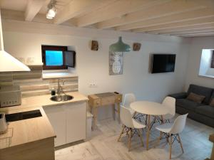 eine Küche und ein Wohnzimmer mit einem Tisch und Stühlen in der Unterkunft Picos de Europa Chic & Cool Apartments in Puertas