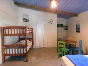 a room with a bunk bed and a table and a desk at El Arrecife Martin Pescador in Taxisco