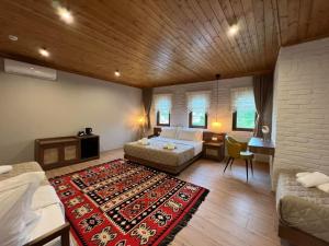 a bedroom with a bed and a couch and a rug at The Stone Sky Hotel in Gjirokastër