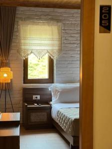 a small bedroom with a bed and a window at The Stone Sky Hotel in Gjirokastër