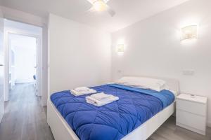- une chambre blanche avec un lit bleu et des serviettes dans l'établissement Copacabana Apartment 4-C Levante Beach, à Benidorm