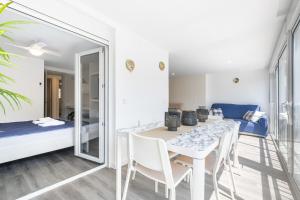 - une salle à manger avec une table, des chaises et un lit dans l'établissement Copacabana Apartment 4-C Levante Beach, à Benidorm
