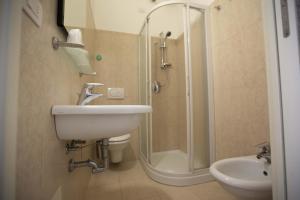 ein Bad mit einer Dusche, einem Waschbecken und einem WC in der Unterkunft Hotel Confort in Rimini