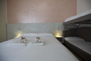 a bedroom with two beds with towels on them at Hotel Confort in Rimini