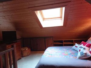 um quarto com uma cama e uma clarabóia em Chalet Chez Nous em Domancy