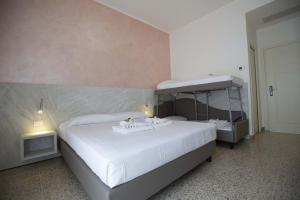 een slaapkamer met een groot wit bed in een kamer bij Hotel Confort in Rimini