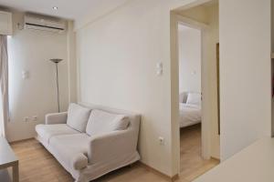 a living room with a white couch and a bed at Lucys Port in Piraeus