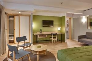 a hotel room with a bed and a table and chairs at Yadoya Hotel in Brussels