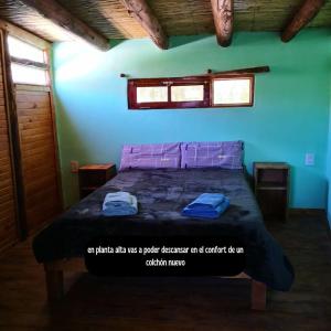 a bedroom with a bed with two towels on it at Reposo del Huasamayo in Tilcara