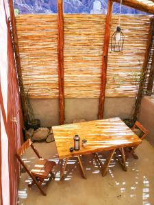 einen Holztisch in einem Zimmer mit einer Wand in der Unterkunft Reposo del Huasamayo in Tilcara