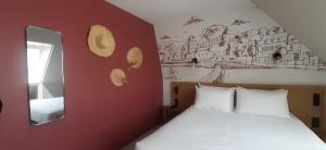 a bedroom with a bed and a painting on the wall at L'Escale Marine, The Originals Relais in Crozon
