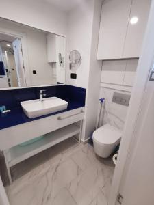 uma casa de banho com um lavatório branco e um WC. em OrbiRest in Batumi em Batumi