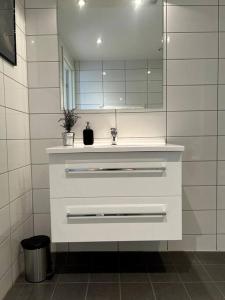 y baño con lavabo y espejo. en Seaside Central Apartment, en Osøyro