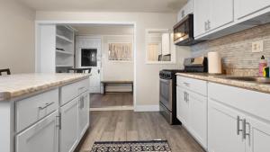 a kitchen with white cabinets and a counter top at Cozy house close to Main St in downtown Leadville! in Leadville +5 photos