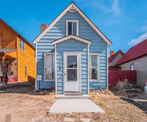 a blue house with a white door in a yard at Cozy house close to Main St in downtown Leadville! in Leadville